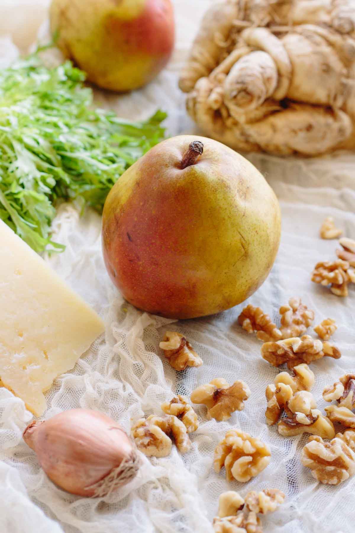 Pears, celery root, frisee, walnuts, a shallot and manchego arranged on cheesecloth.