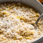 A close, detailed view of creamy pastina in a bowl, showing the soft grains, melted cheese and olive oil pooling on top.