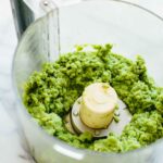 Fresh homemade Thai green curry paste blended in a food processor until thick and bright green.