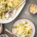 Top view of shaved fennel salad served into a single plate with a fork.