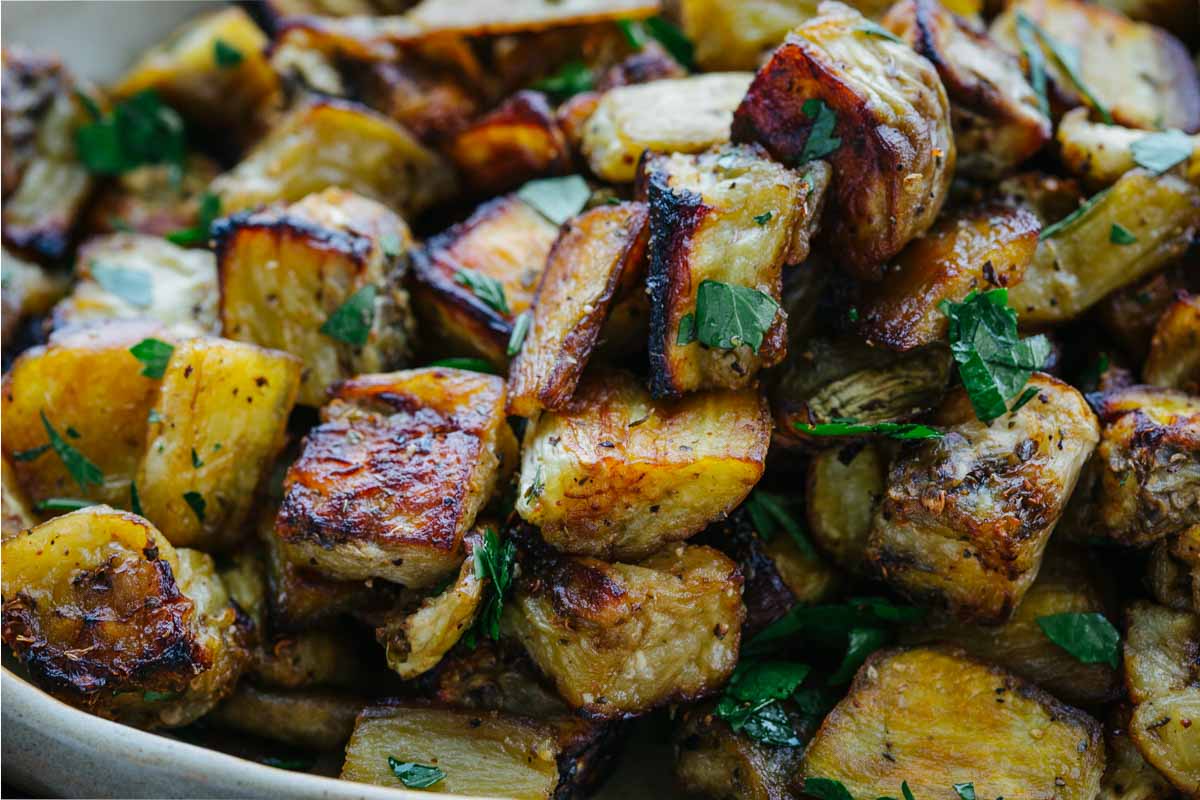 Macro shot of crispy roasted eggplant showing caramelized edges and parsley garnish.